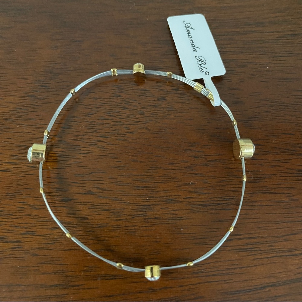Wire bangle bracelet with silver and gold tones. Clear gems. Amanda Blu.
